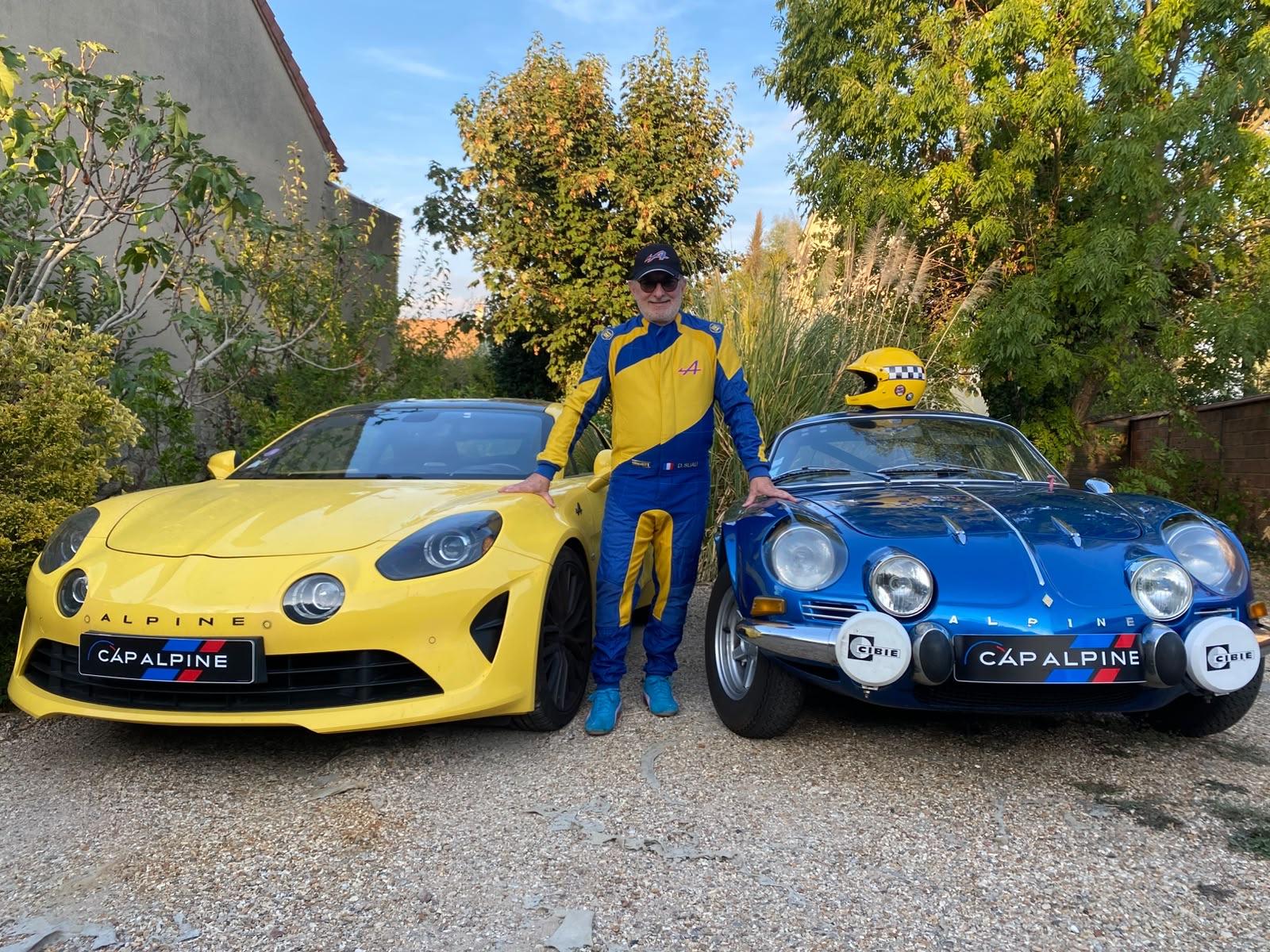 Un membre du club en combinaison entre une A110 jaune et une berlinette bleue